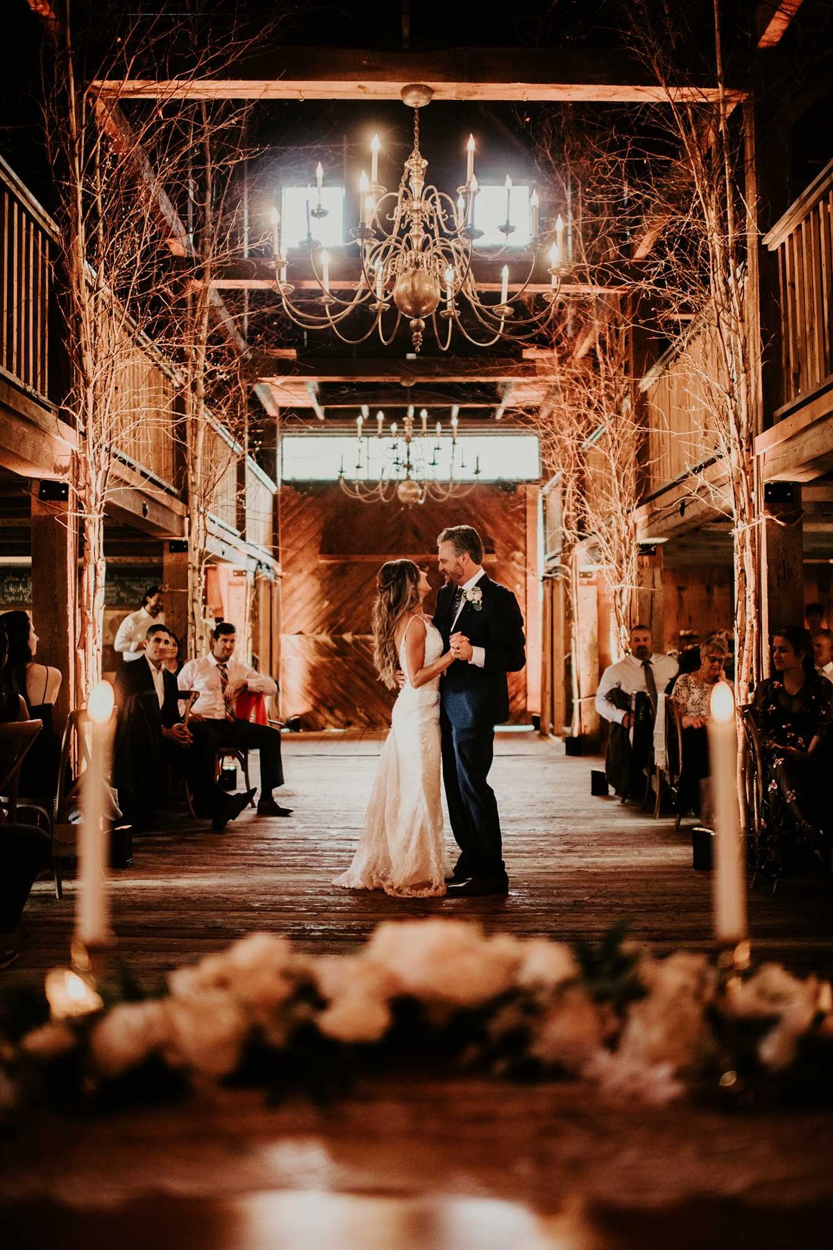 A couple celebrating in a warmly lit New Hampshire barn wedding venue
